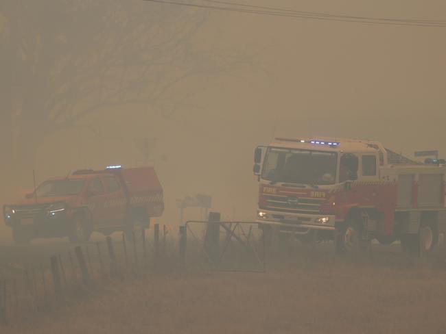 TFS personnel in thick smoke at the Elderslie Rd bushfire. Picture: LUKE BOWDEN