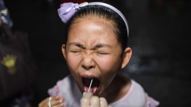 A child receives a nucleic acid test for Covid-19 at a residential area in Wuhan last week. Picture: AFP