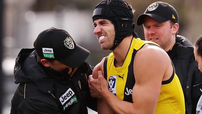 Richmond’s Ben Griffiths in the hands of medicos. Picture: Michael Klein