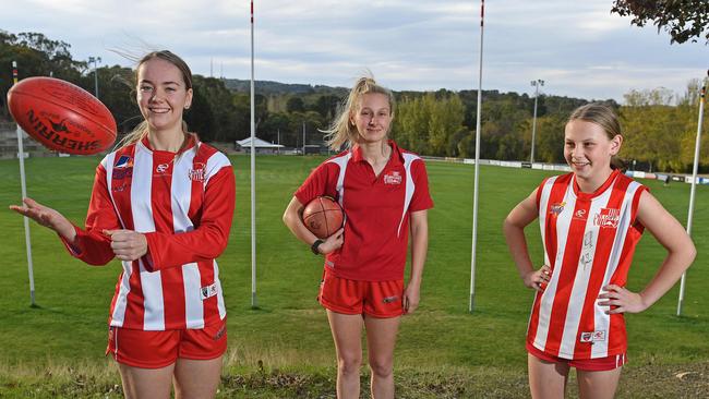 Mount Lofty senior women’s players Maddy Taylor (jumper) and Holly Aiston (polo) with under-14 rising star Keira May, can’t wait to get back to playing footy. Picture: Tom Huntley