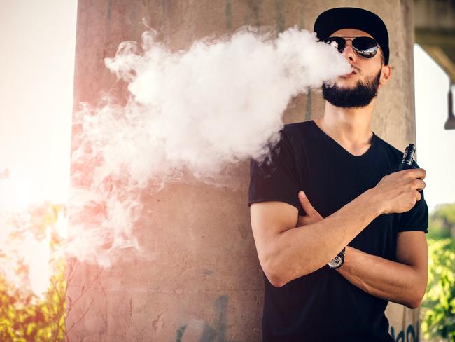 Men with beard vaping outdoor in sunglasses   istock image