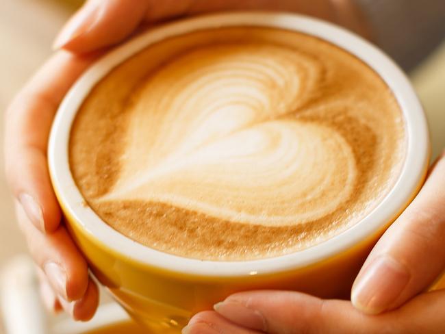 lady's hands hold cup filled with something heart-shaped