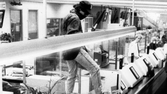 Christopher Dean Binse aka “Badness” mounting the counter during a 1992 armed holdup at a Commonwealth Bank. Picture: Supplied