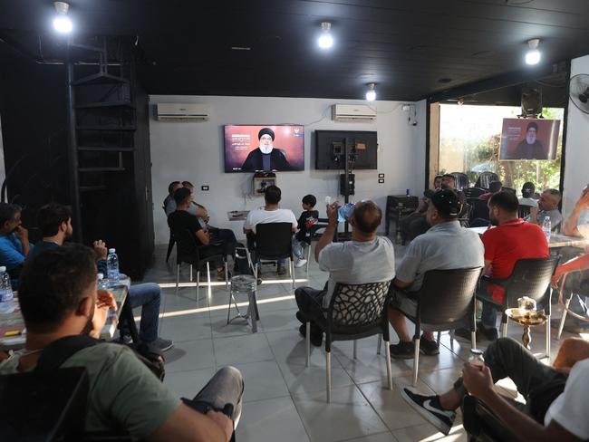 People sitting in a cafe watch the televised speech of Lebanon's Hezbollah chief Hasan Nasrallah, in the Shaih district of Beirut's southern suburbs. Picture: AFP