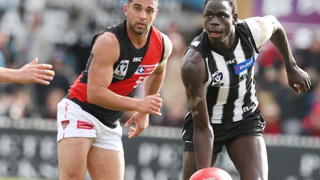 Collingwood’s Tom Jok clears by hand. Photo: Michael Klein