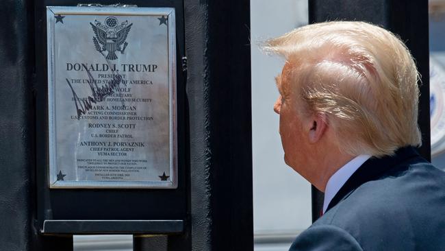 US President Donald Trump looks at a plaque after signing it to mark the 200th mile of border wall. Picture: Saul Loeb/AFP