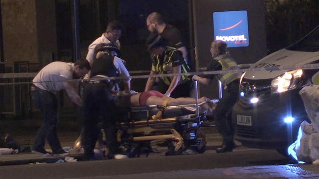 A man is treated on a stretcher for stab wounds in Thrale Street near London Bridge. Picture: AP