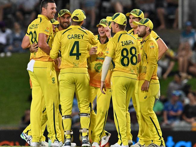 Australia's Josh Hazlewood (L) celebrate the wicket of New Zealand's Daryl Mitchell with teammates during the third one-day international (ODI) cricket match between Australia and New Zealand at the Cazalys Stadium in Cairns on September 11, 2022. (Photo by Saeed Khan / AFP)