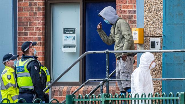 A resident at one of the public housing towers under lockdown in Flemington argues with police. Picture: Jake Nowakowski