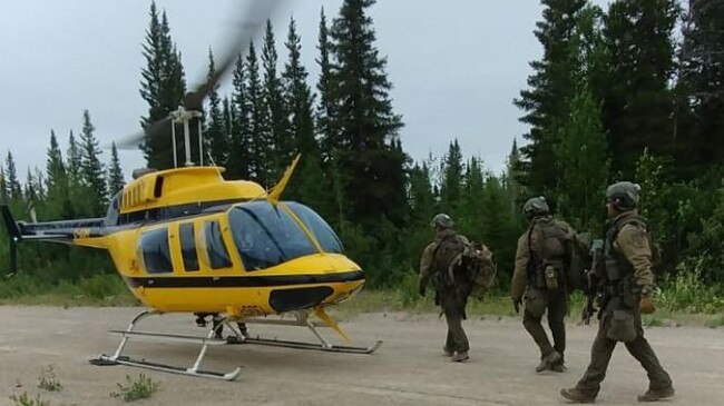 Police board helicopter as the fugitive hunt intensifies. Picture: RCMP.