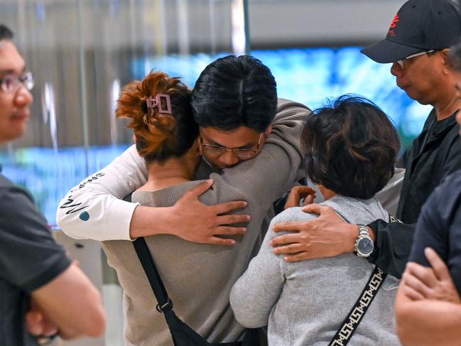 Passengers of Singapore Airlines flight SQ321 greet family members upon arrival at Changi Airport in Singapore. Picture: Roslan Rahman/AFP