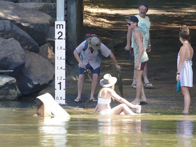 A woman can be seen sitting in the water of Cahills Crossing. Picture: Charlotte Nansen