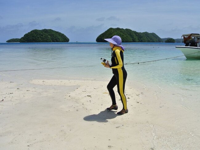 A Chinese tourist walking on a beach on the Rock Islands in Palau. Visitors to the tiny Pacific nation of Palau were made to sign a promise to respect the environment. Picture: AFP