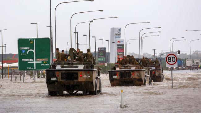 Australia's military has been deployed to tackle devastating "once-in-a-century" floods that have inundated homes, schools and airports in the country's northeast, forcing hundreds to flee and bringing crocodiles onto the streets. (Photo by STR / AFP)