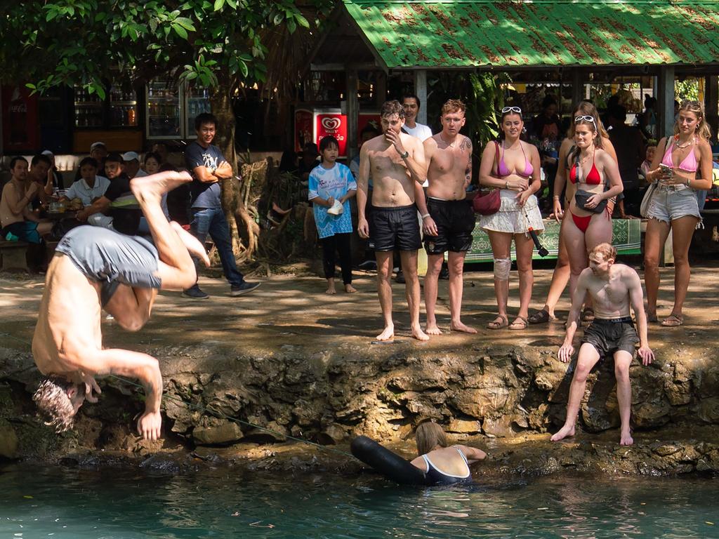 Tourists play in the water as they visit the Phukham Cave lagoon in Vang Vieng on November 24. The Laos government said on November 23 it was "profoundly saddened" by the deaths of six foreign tourists that included the two Australian teenagers. Picture: AFP