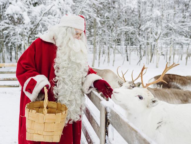 Santa Claus feeding reindeer at Rovaniemi, Lapland, Finland. Picture: Visit Rovaniemi