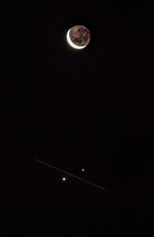 An incredible image of the International Space Station passing between Jupiter and Saturn during a Great Conjunction of the two planets as the moon looms overhead. Picture: Jason De Freitas