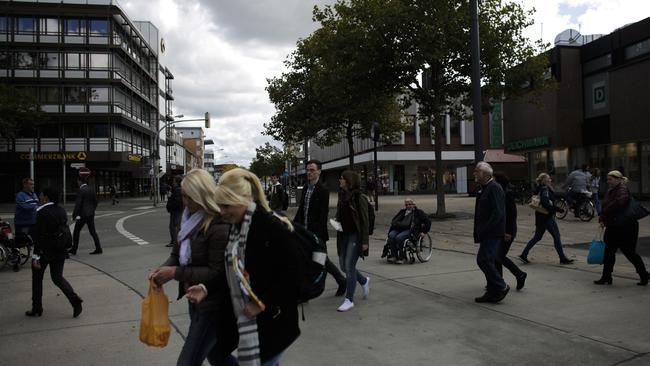 People cross a street in the centre of Wolfsburg.