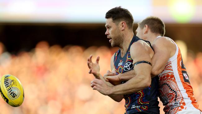 Sam Gibson under pressure from Giant Josh Kelly. Picture: James Elsby/AFL Media/Getty Images