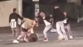 A man is punched while on the ground.