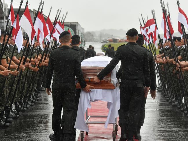 A military guard of honor receives the coffins of the members of the Chapecoense Real football club team killed in a plane crash in Colombia, upon their arrival at the airport of Chapeco, in Santa Catarina, southern Brazil, on December 3, 2016. The first of two Brazilian air force planes carrying the remains of a football team killed in a plane crash arrived Saturday in the city of Chapeco in southern Brazil. / AFP PHOTO / Nelson Almeida