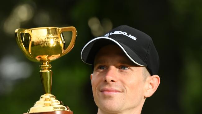 Lexus Melbourne Cup 2020 winner Jye McNeil poses with the 2020 Melbourne Cup. Picture: supplied