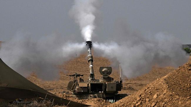 An Israeli army M109 155mm self-propelled howitzer fires rounds toward the Gaza Strip from a position in southern Israel across the border on Saturday. Picture: AFP