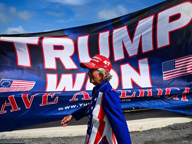 Supporters of former US president and Republican presidential candidate Donald Trump celebrate his victory near his Mar-a-Lago resort in Palm Beach, Florida, on November 6, 2024. Donald Trump won a sweeping victory Wednesday in the US presidential election, defeating Kamala Harris to complete an astonishing political comeback that sent shock waves around the world. (Photo by CHANDAN KHANNA / AFP)