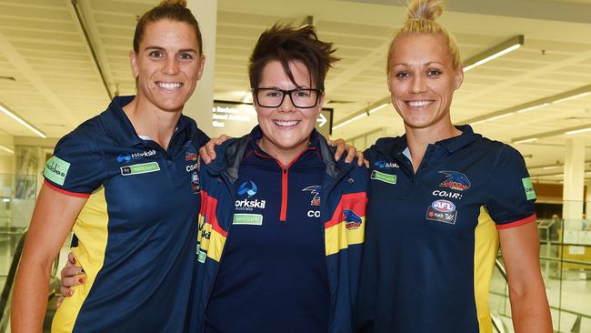 Crows coach Bec Goddard, centre, with co-captains Chelsea Randall, left, and Erin Phillips at Adelaide airport.