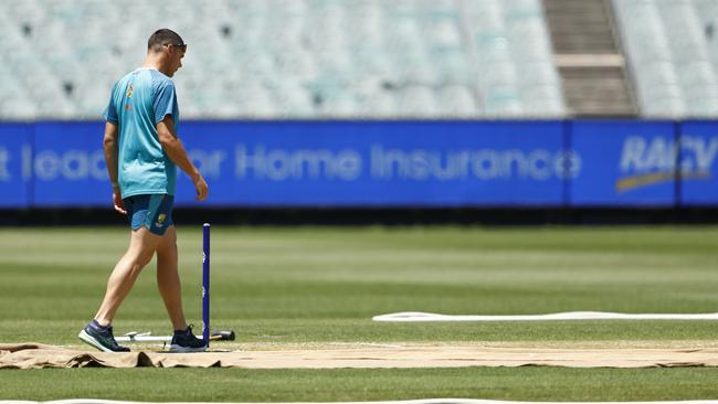 Scott Boland inspects the M.C.G. wicket. (Photo by Darrian Traynor/Getty Images)