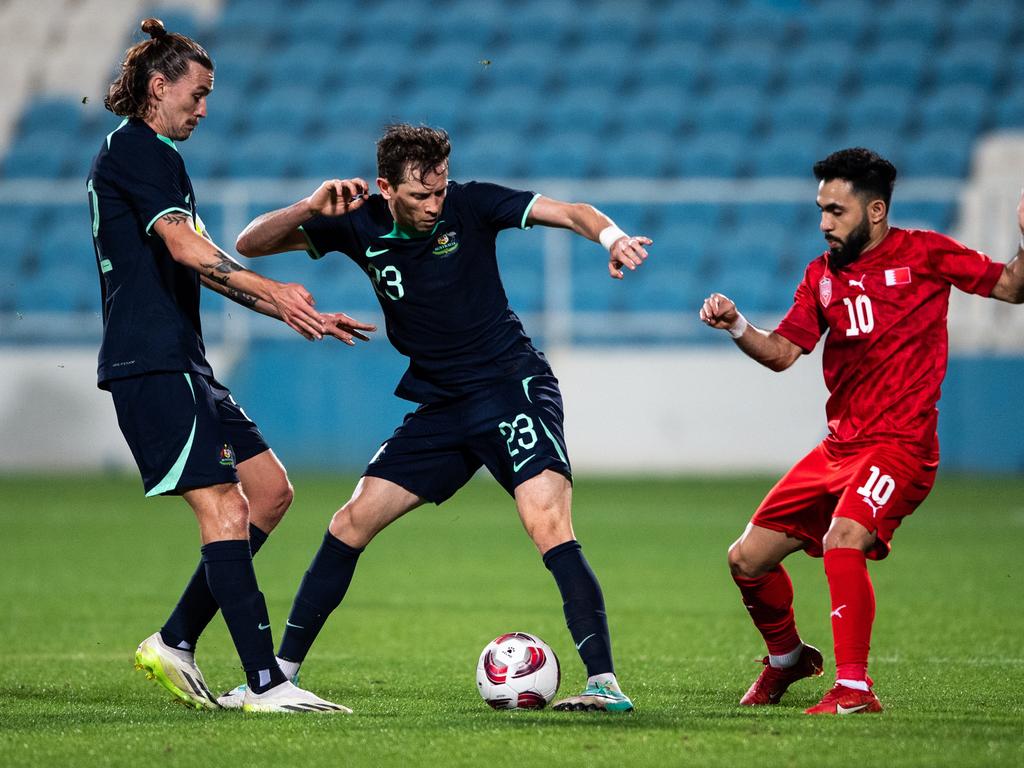 Socceroos pair Jackson Irvine (left) and Craig Goodwin (centre) battle for the ball with Bahrain's Komail Alaswad during Australia’s 2-0 win. Picture: Martin Dokoupil/Getty Images