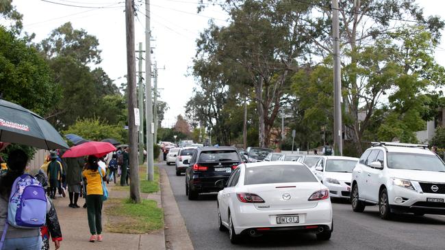 Backed up Traffic outside Carlingford West Public School which is currently using teachers to direct traffic to deal with the pick-up hour. Picture: Jonathan Ng