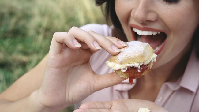 A woman eating a scone. Photo: File