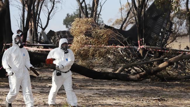 ATSB Transport Safety Investigators retrieving the Cockpit Voice Recorder from the wreckage of the C-130 Hercules air tanker. Picture: AAP