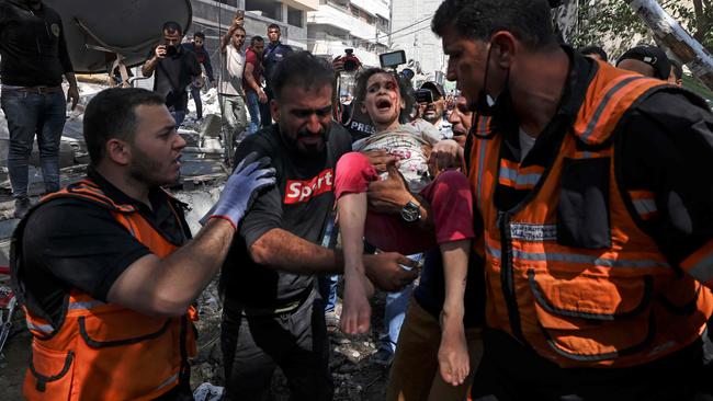 Palestinian paramedics evacuate a girl from the rubble of a destroyed building in Gaza City's Rimal residential district on Sunday. Picture: AFP