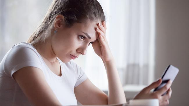 Angry young woman looking at smartphone frustrated by no signal or scam message, mad female disappointed by bad news reading on phone, upset girl get negative or rejection response on mobile; generic scam