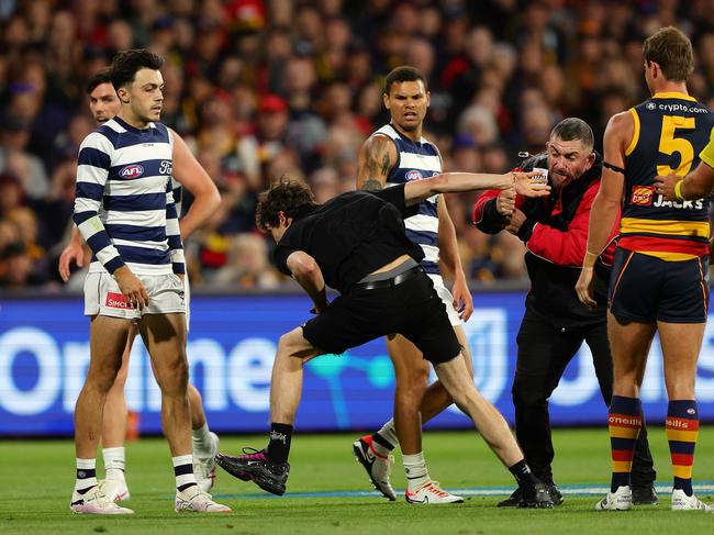 ADELAIDE, AUSTRALIA - MARCH 22: A pitch invader breaks away from security during the 2024 AFL Round 2 match between the Adelaide Crows and the Geelong Cats at Adelaide Oval on March 22, 2024 in Adelaide, Australia. (Photo by Sarah Reed/AFL Photos via Getty Images)