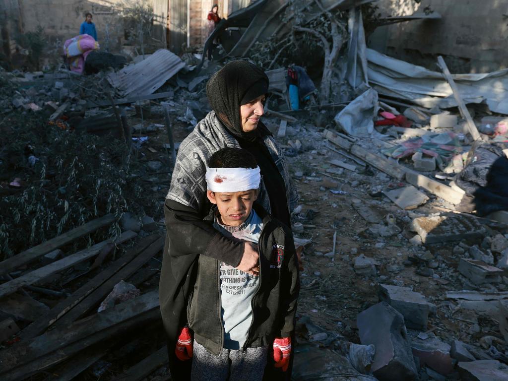 A Palestinian woman comforts a boy amid the ruins in Rafah, Gaza, following an Israeli air strike during the conflict with Hamas. Picture: AFP