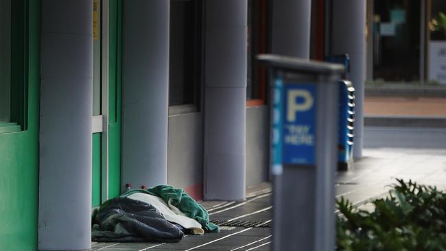 Rugged up against the cold, a homeless person sleeps on Young Street. Picture: Glenn Hampson