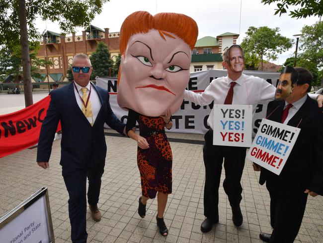 Protesters wearing mask depicting One Nation leader Pauline Hanson, Prime Minister Malcolm Turnbull and Gautam Adani (right) are seen outside the Queensland LNP (Liberal National Party) state convention. Picture: AAP