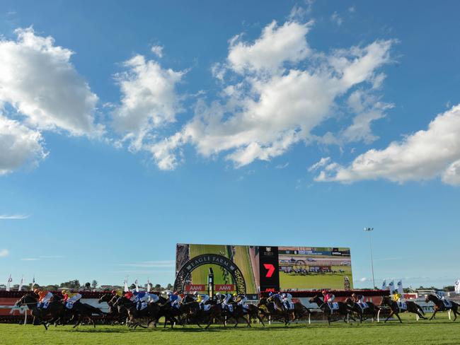 The field passes the finish post on the first occasion in Queensland Derby. Picture: AAP