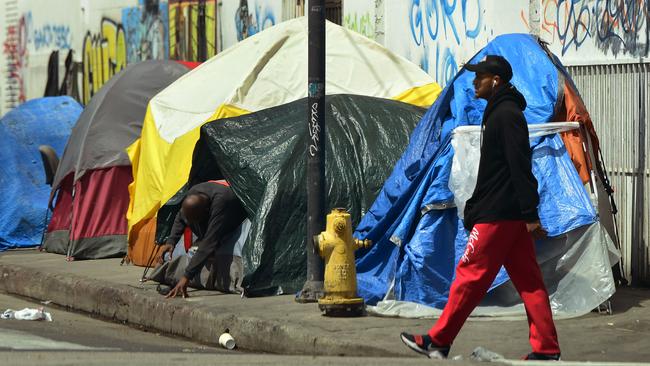 A person makes his way out of his tent among a row of tents along a sidewalk in downtown Los Angeles. Picture: Frederic J. Brown/AFP