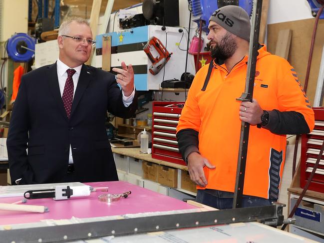 SYDNEY, AUSTRALIA - JULY 20: Prime Minister Scott Morrison speaks to Johnny Jackson as he is shown around his work area during a visit to the DisplayWise workshop in Miranda on July 20, 2020 in Sydney, Australia. The Federal Government is set to announce changes to the JobKeeper and JobSeeker programs this week when Treasurer Josh Frydenburg releases a budget update on Thursday 23 July. The wage subsidy and the boosted unemployment benefit programs introduced in response to the COVID-19 are set to end in September, however are expected to be revised and extended . (Photo by Mark Kolbe/Getty Images)