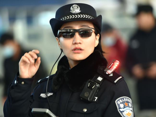 This photo taken on February 5, 2018 shows a police officer wearing a pair of smartglasses with a facial recognition system at Zhengzhou East Railway Station in Zhengzhou in China's central Henan province. Chinese police are sporting hi-tech sunglasses that can spot suspects in a crowded train station, the newest use of facial recognition that has drawn concerns. Picture: AFP