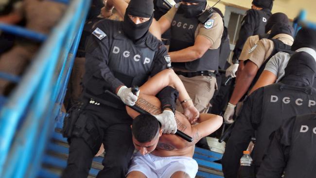 Security forces tackle gang members at an El Salvador jail. Picture: AFP