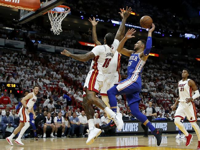 Ben Simmons soars over two defenders.