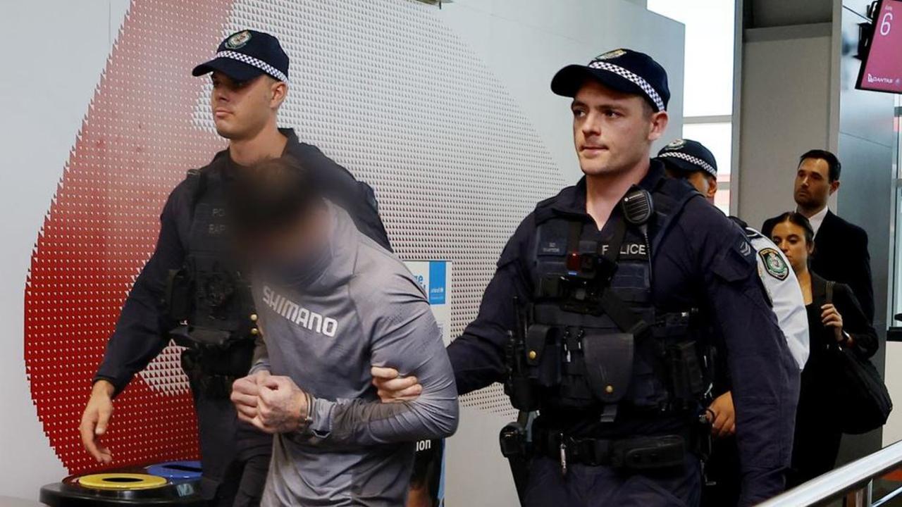 The former fugitive bowed his head as he was taken through Sydney Airport. Picture: supplied by NSW Police