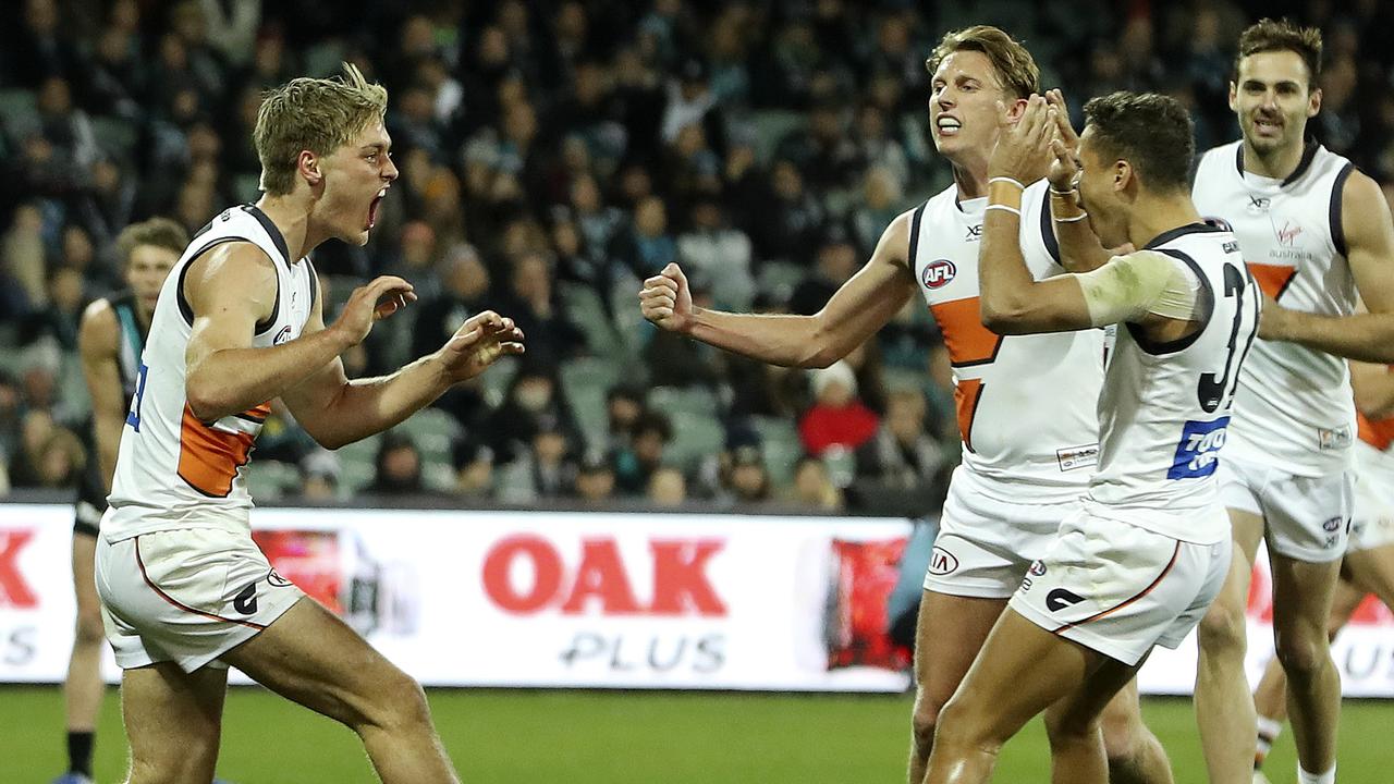 Hately, left, celebrates his first goal with GWS teammates Lachie Whitfield and Bobby Hill.. Picture: SARAH REED