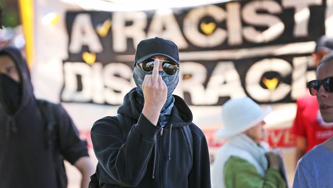 An anti-racism protester shows his dislike for the media. Picture: Nathan Dyer