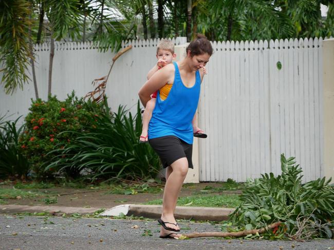 Tropical Cyclone Kirrily 2024: A mother and son survey damage to gardens at houses and the primary school on Potts Street, Belgian Gardens.